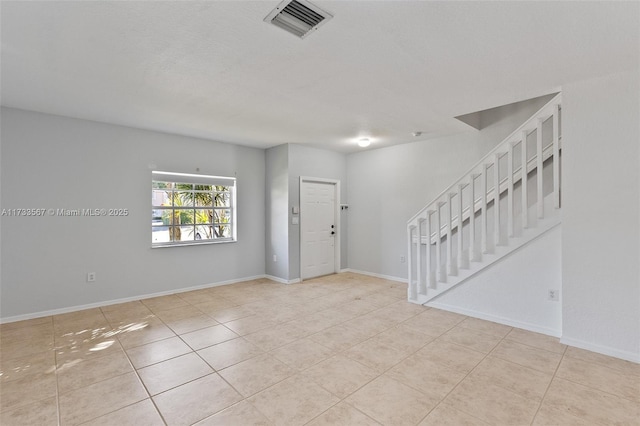 spare room with light tile patterned flooring and a textured ceiling