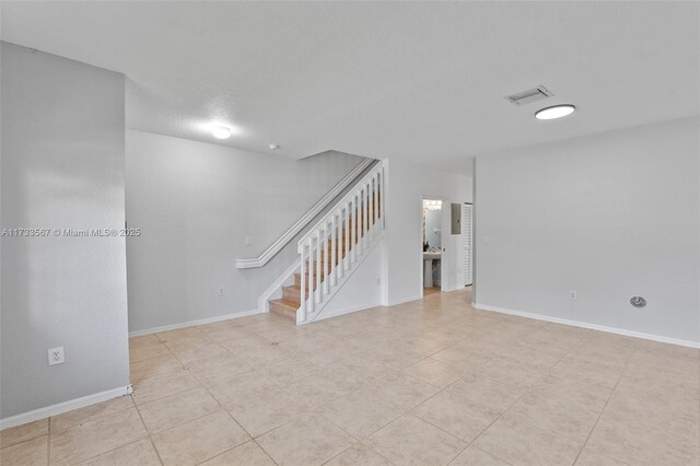 spare room with light tile patterned floors and a textured ceiling