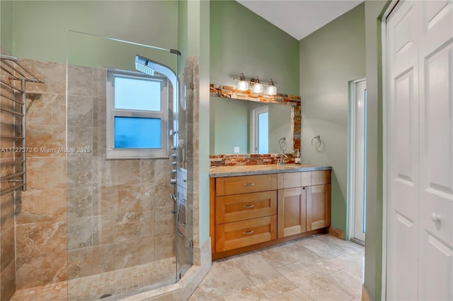 bathroom featuring a tile shower and vanity