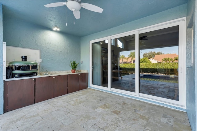 view of patio with sink, grilling area, ceiling fan, and an outdoor kitchen