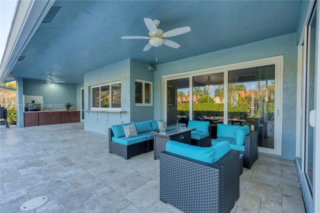 view of patio / terrace featuring ceiling fan, an outdoor hangout area, and exterior kitchen