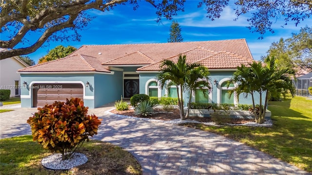 mediterranean / spanish-style home featuring a garage and a front yard