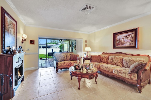 living room featuring ornamental molding, light tile patterned floors, and a textured ceiling