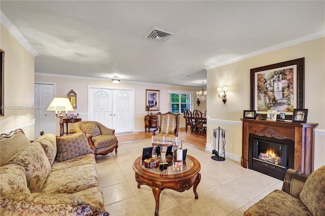 living room featuring an inviting chandelier, ornamental molding, a textured ceiling, and light tile patterned floors