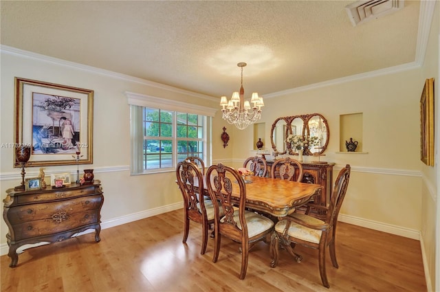 dining room with crown molding, hardwood / wood-style floors, and a textured ceiling