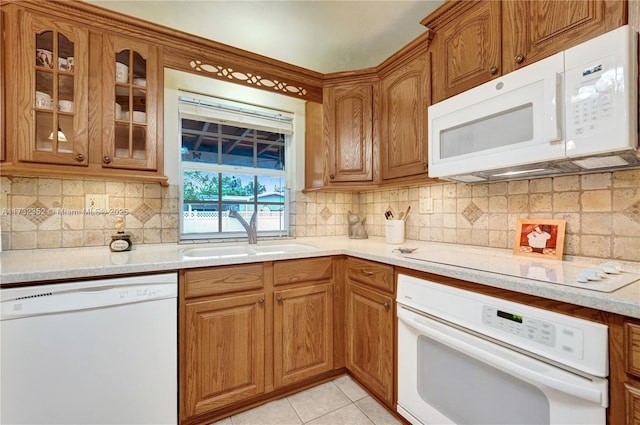 kitchen featuring light tile patterned flooring, white appliances, sink, and tasteful backsplash