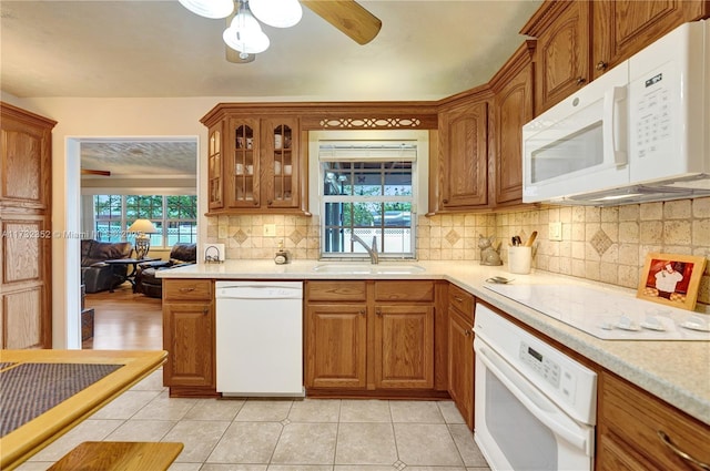 kitchen featuring backsplash, white appliances, sink, and light tile patterned floors