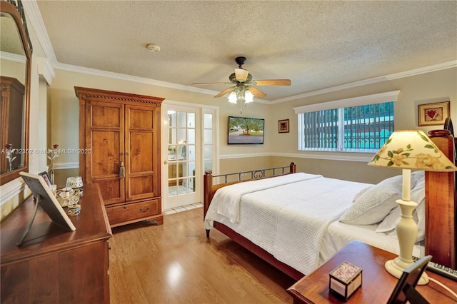 bedroom featuring crown molding, a textured ceiling, ceiling fan, and light hardwood / wood-style flooring