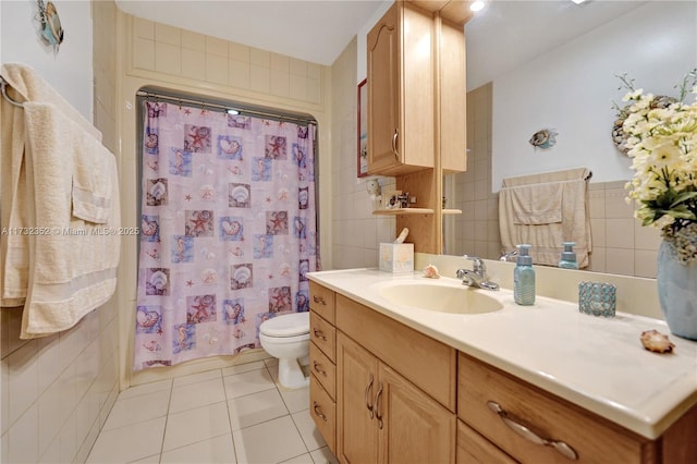 bathroom featuring tile patterned flooring, tile walls, a shower with shower curtain, vanity, and toilet