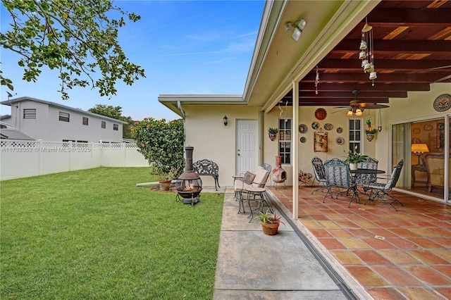 view of yard with ceiling fan, an outdoor fire pit, and a patio area