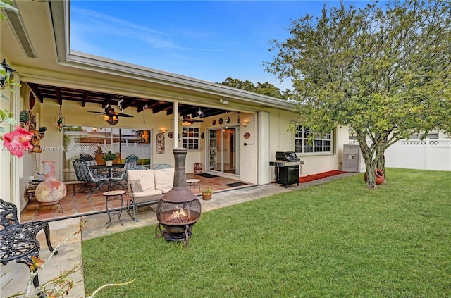 rear view of house with a yard, a fire pit, and a patio