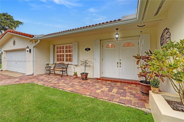 property entrance with a garage and a lawn