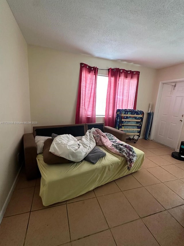 bedroom featuring a textured ceiling and light tile patterned flooring