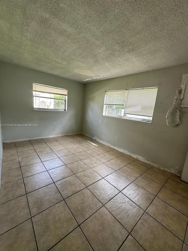 spare room with plenty of natural light and a textured ceiling