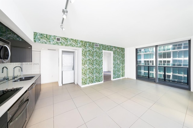 kitchen with sink, rail lighting, appliances with stainless steel finishes, and light tile patterned flooring