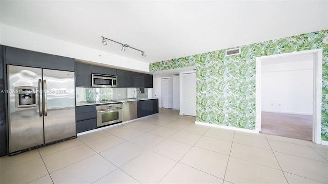 kitchen featuring stainless steel appliances, sink, and light tile patterned floors