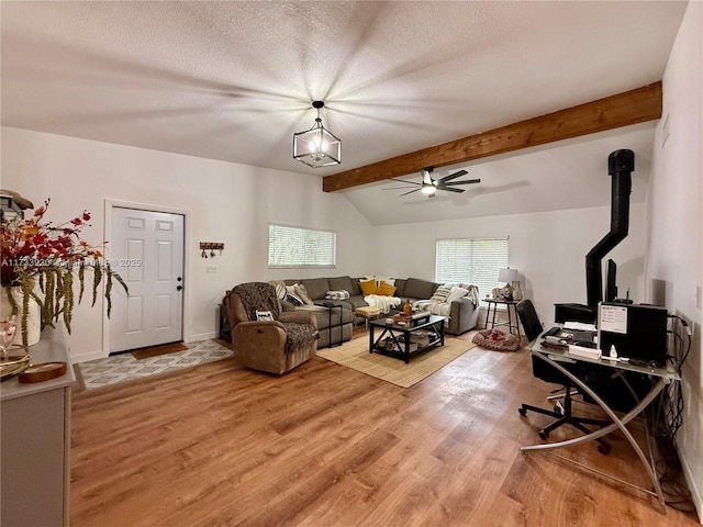 living room featuring ceiling fan, hardwood / wood-style flooring, lofted ceiling with beams, and a textured ceiling