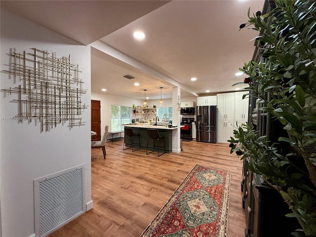 living room with sink and light hardwood / wood-style floors