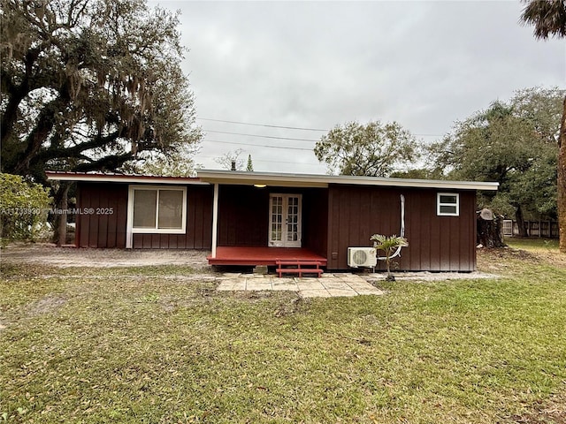 back of property with french doors and a lawn