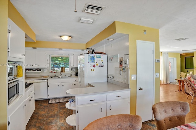 kitchen featuring tasteful backsplash, sink, white cabinets, and white appliances