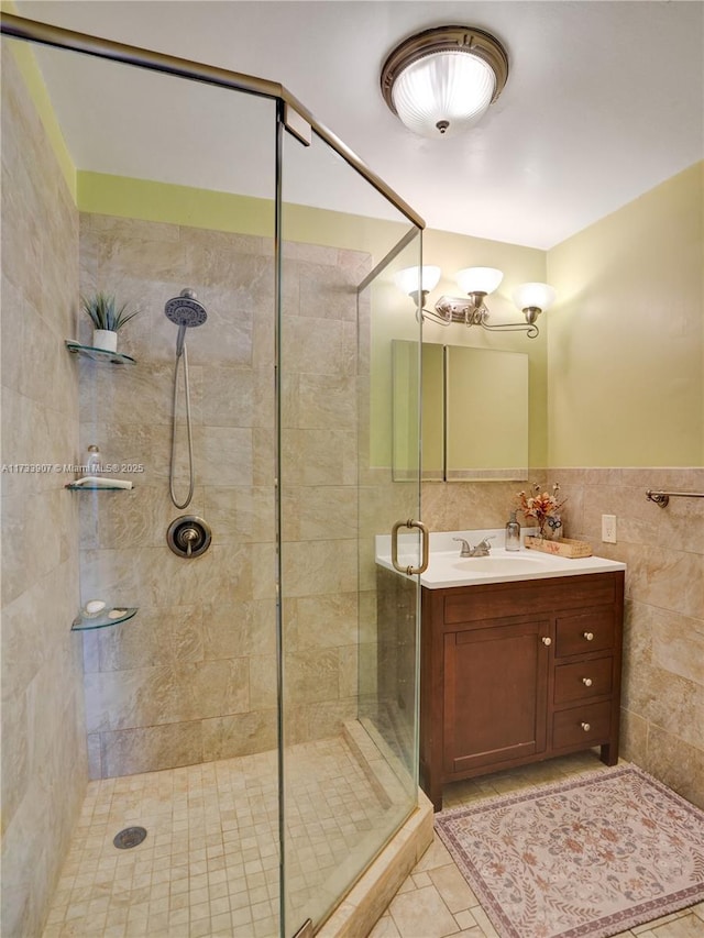 bathroom with vanity, tile walls, tile patterned floors, and a shower with shower door