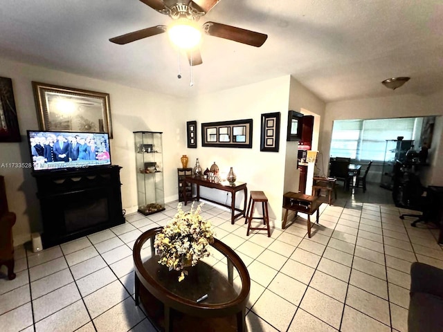 living room with ceiling fan, a fireplace, and light tile patterned floors