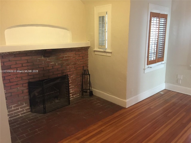 unfurnished living room featuring dark wood-type flooring and a fireplace