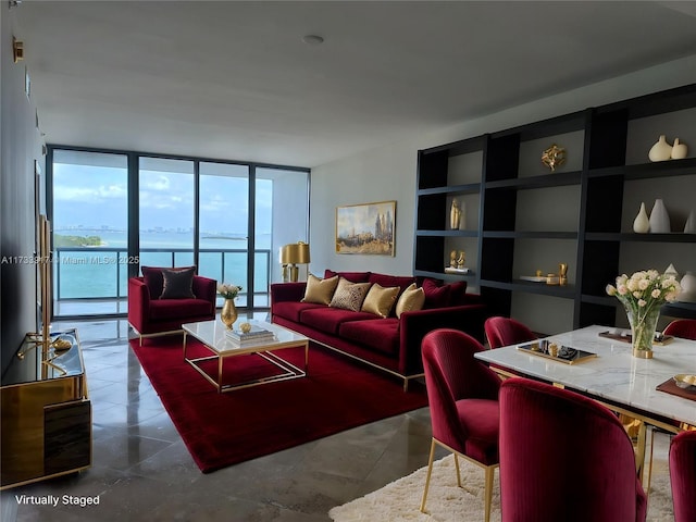 living room with a wall of windows, a water view, and built in shelves