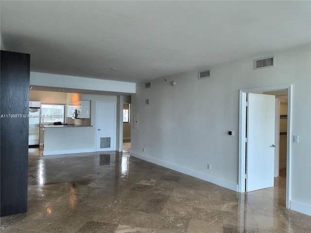 unfurnished living room featuring baseboards and visible vents
