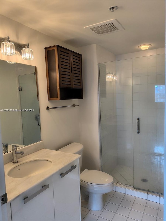 bathroom with vanity, a shower with shower door, tile patterned floors, and toilet