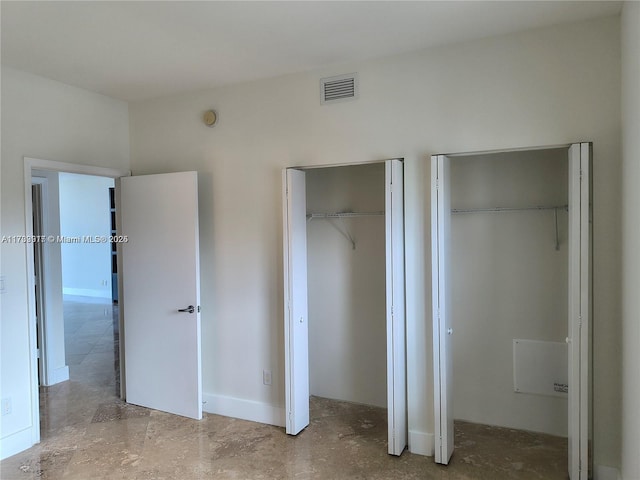 unfurnished bedroom with multiple closets