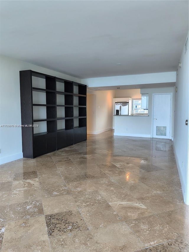 spare room featuring baseboards, visible vents, and stone finish floor