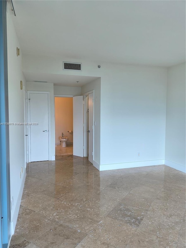 empty room with visible vents and baseboards