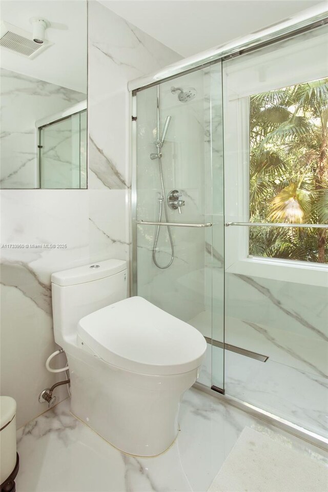 bathroom with an enclosed shower and toilet