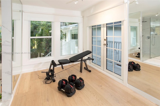 workout room with hardwood / wood-style flooring and french doors