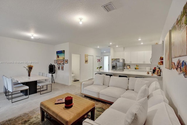 tiled living room featuring a textured ceiling