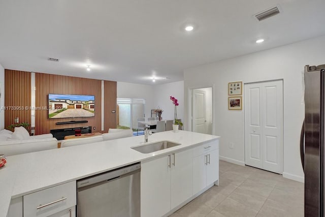 kitchen featuring light tile patterned flooring, sink, refrigerator, stainless steel dishwasher, and white cabinets