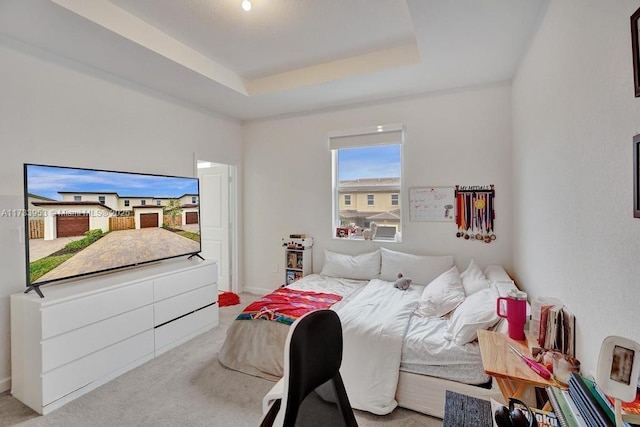 carpeted bedroom with a raised ceiling