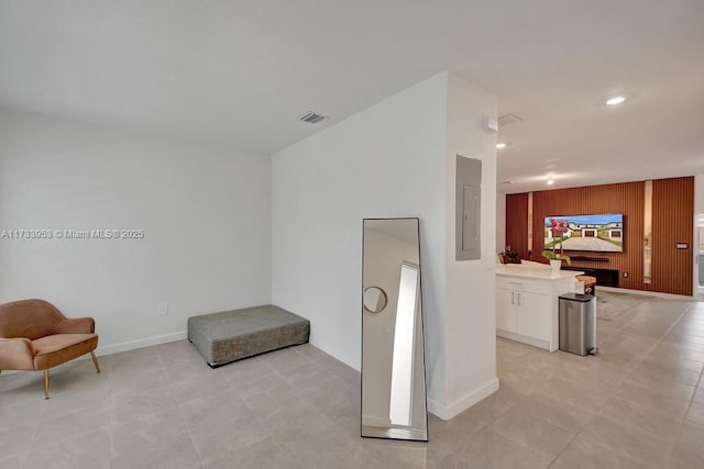 sitting room with wooden walls and electric panel