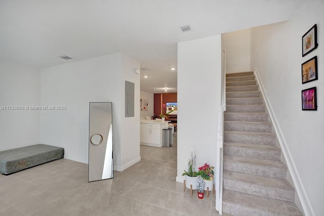 stairs with electric panel and tile patterned flooring