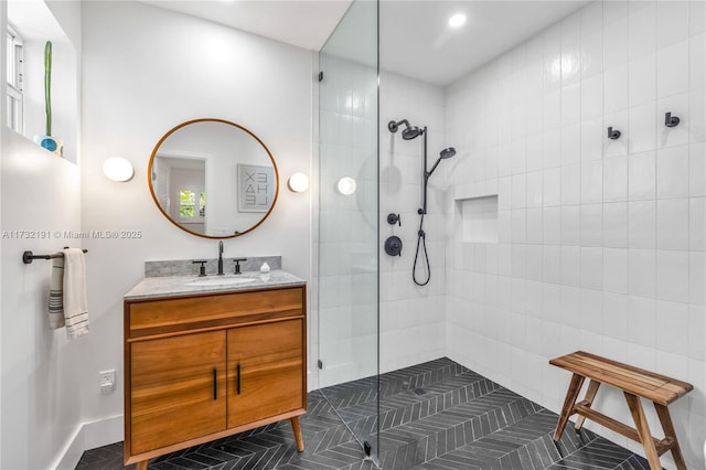 bathroom featuring tile patterned floors, vanity, and a tile shower