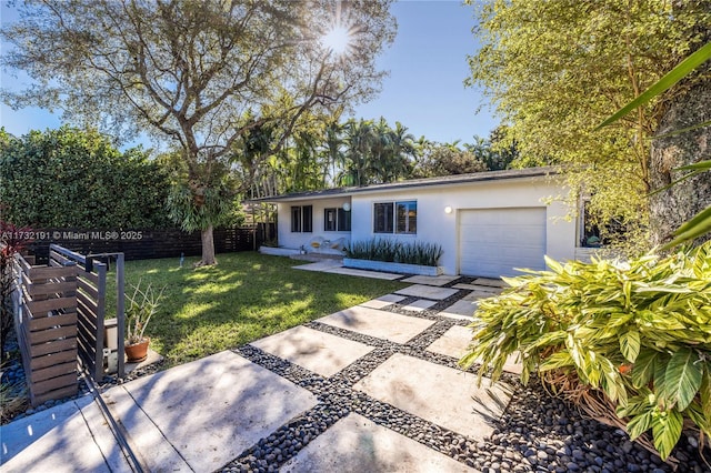 view of front of house featuring a garage and a front lawn