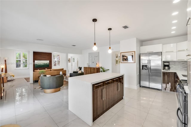 kitchen with pendant lighting, appliances with stainless steel finishes, dark brown cabinetry, white cabinets, and decorative backsplash