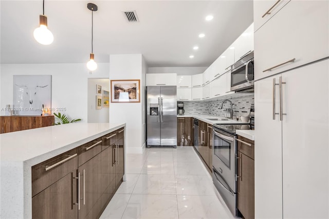 kitchen with sink, hanging light fixtures, stainless steel appliances, dark brown cabinetry, and white cabinets