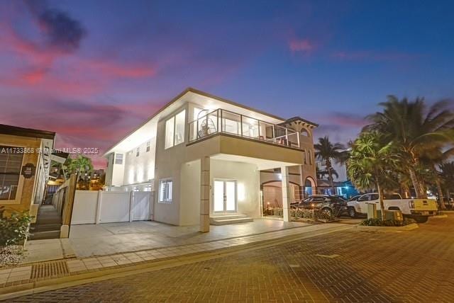 back house at dusk featuring a balcony