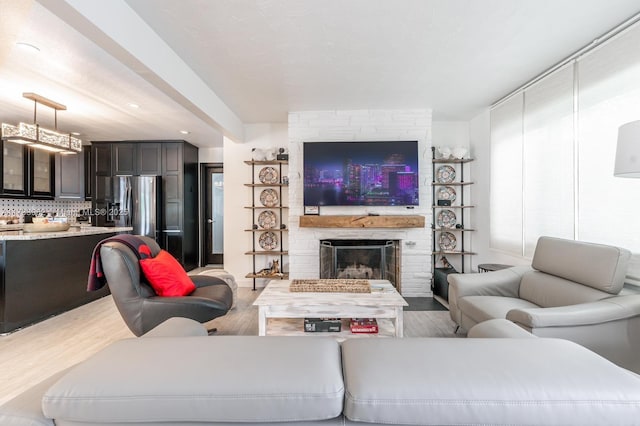 living room with wood-type flooring and a brick fireplace