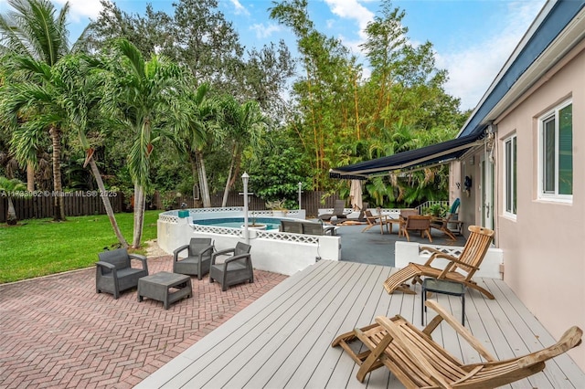 wooden deck with a fenced in pool, an outdoor hangout area, a yard, and a patio area