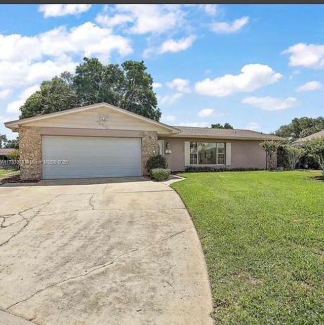 single story home featuring a garage and a front lawn