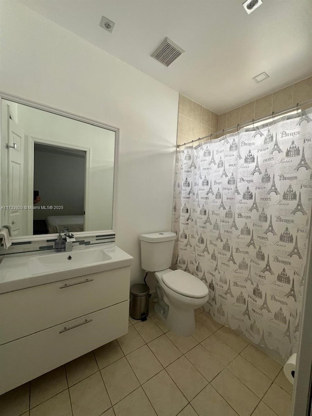 bathroom with tile patterned flooring, vanity, and toilet