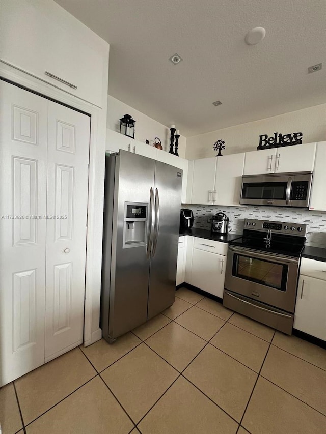 kitchen featuring white cabinetry, appliances with stainless steel finishes, tasteful backsplash, and light tile patterned floors